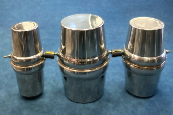 The Trongos comprise of three silver barrels, joined side by side, forming a single, unified body. The central Trongo is larger than the two outer barrels, creating a subtle visual and acoustic hierarchy. Each barrel features a circular opening in its upper half, allowing water to be added.